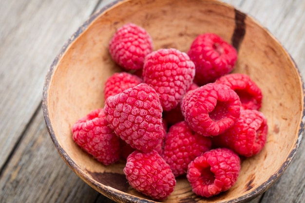 Frozen raspberries on wooden table.