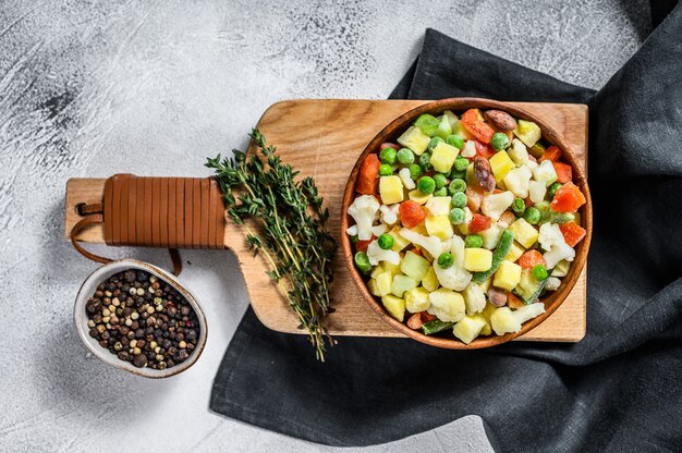 Frozen raw vegetables in a bowl. Vegetarianism. White background. 