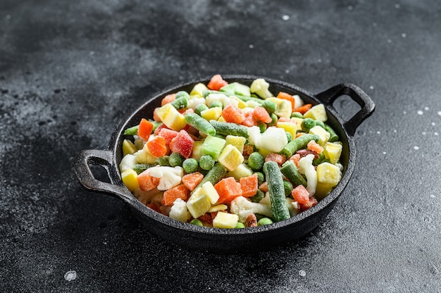 Frozen raw vegetables in a pan.