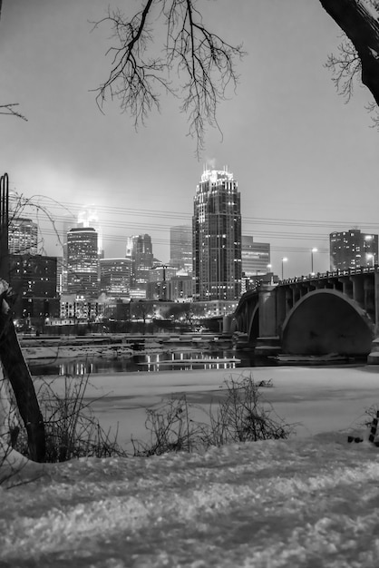 Photo frozen river by buildings against sky during winter