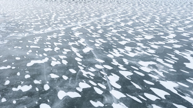 雪冬の氷の背景で覆われた凍った川