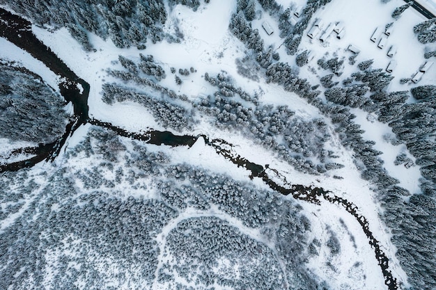 Frozen River in Snow Covered Forest Top Down Drone View