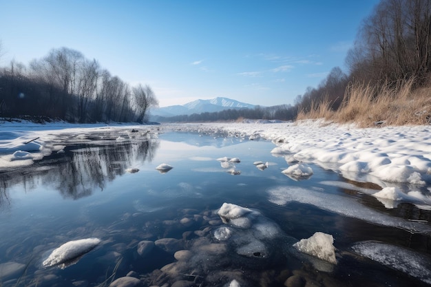 Frozen river with view of distant mountain range and reflection of the sky