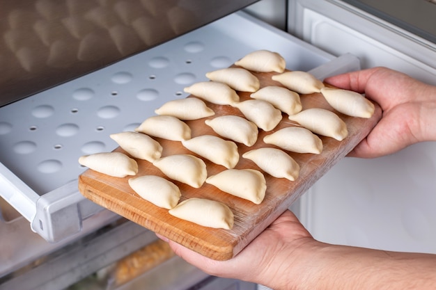 Frozen semi-finished products dumplings in freezer. Food delivery and eat at home concept. Frozen food concept.