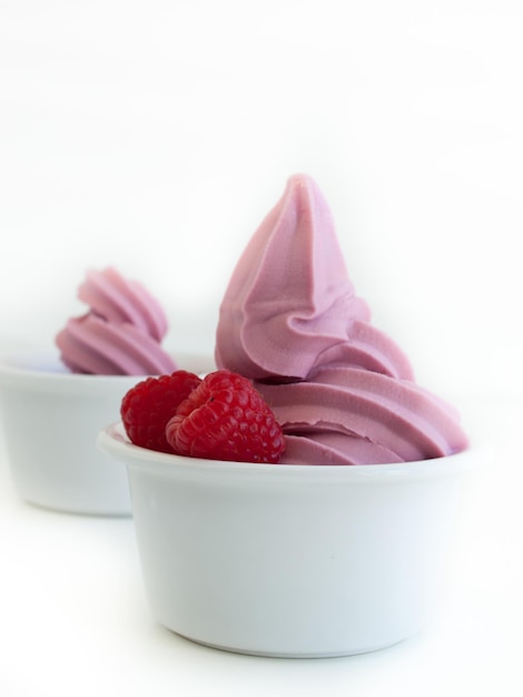 Frozen soft-serve yogurt in cup on white background.