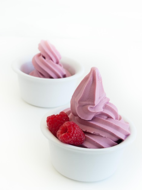 Foto yogurt soft-serve congelato in tazza su sfondo bianco.