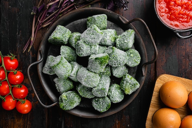 Frozen spinach blocks set, on old dark  wooden table background, top view flat lay