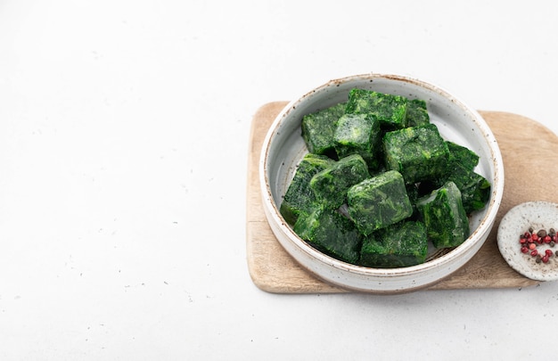 Frozen spinach on a wooden cutting board