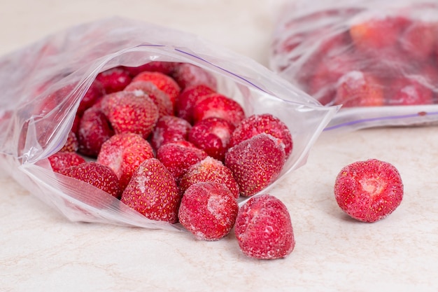 Frozen strawberries in bags, close up. Stocks of meal for the winter.