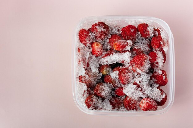 Frozen strawberries in a square container copy space