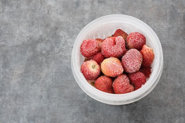 Frozen Strawberries with ice crystals on dark background