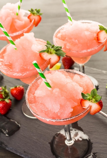 Frozen strawberry margarita cocktail in margarita glass.