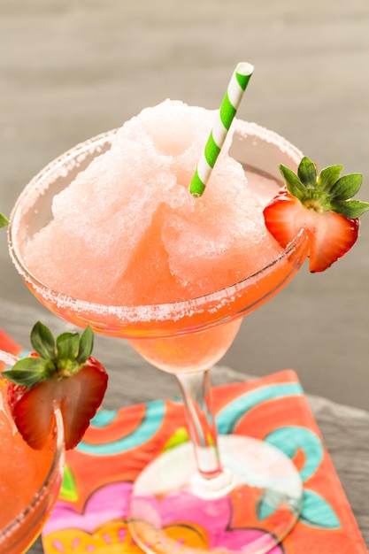 Frozen strawberry margarita cocktail in margarita glass.