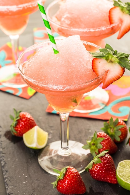 Frozen strawberry margarita cocktail in margarita glass.