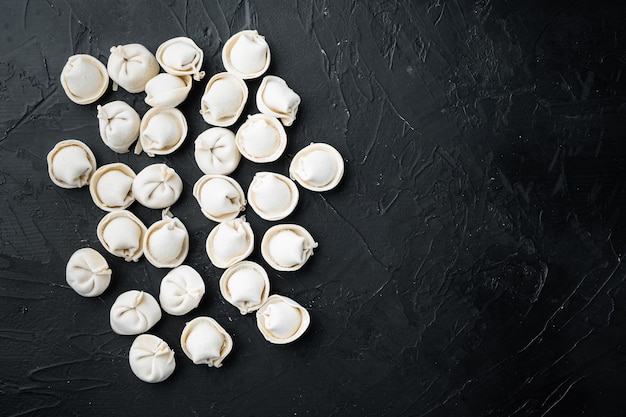 Frozen tortellini set, on black background, top view flat lay , with copyspace  and space for text