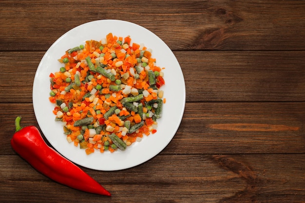 Frozen vegetables carrots peas beans in a plate