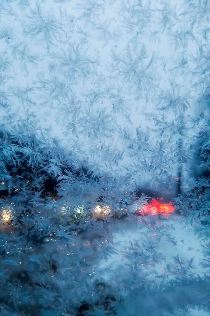 Frozen window the snowflakes the lights of the city