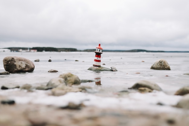 Mare invernale ghiacciato con faro decorativo. stile di vita nautico. inverno, mare, viaggi, avventura, vacanze e concetto di vacanza. viaggia nel 2021