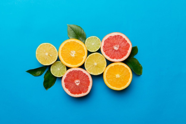 Fruit background Colorful fresh fruits on colored table Orange lemon grapefruit Space for text healthy concept Flat lay top view copy space