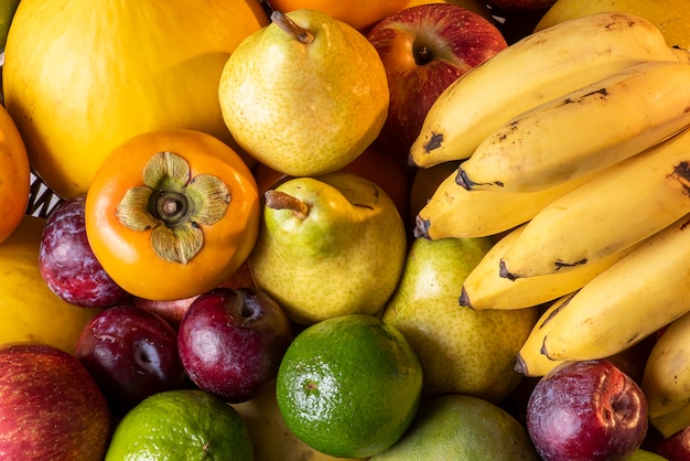 Fruit basket. Apple, lemon, mango, plum., melon, banana, pear and persimmon.