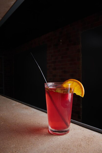 Fruit berry lemonade in glass on table lemon slice straw fruit drink dark background