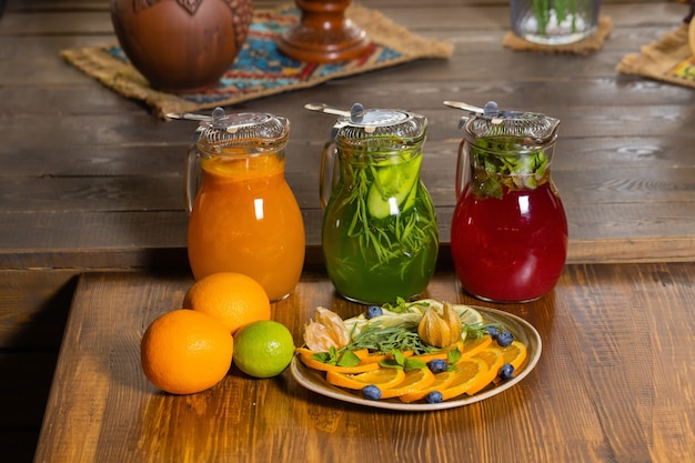 Fruit and berry lemonades on the wooden tray with spruce