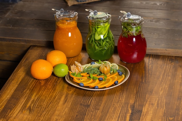 Fruit and berry lemonades on the wooden tray with spruce