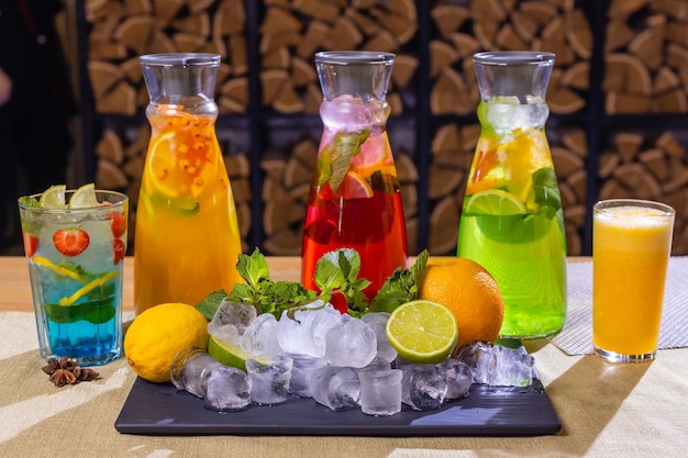 Fruit and berry lemonades on the wooden tray with spruce