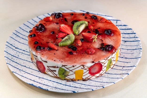 Photo fruit and berry mousse cake on a plate