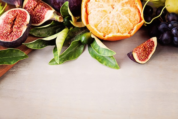 Fruit Border of Grape, Tangerines, Figs on Wooden Background. Healthy Eating