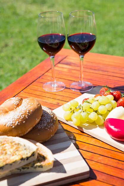 Fruit, bread and wine glass on wooden table