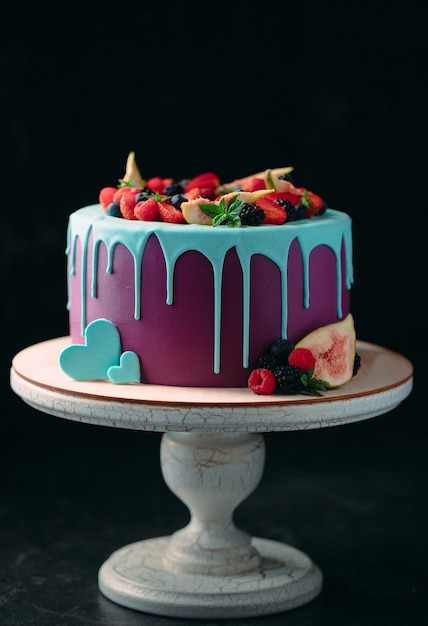 Fruit cake decorated with figs, blueberries, raspberries and mint.