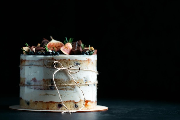 Фото Фруктовый торт, украшенный инжиром, печеньем и черникой.