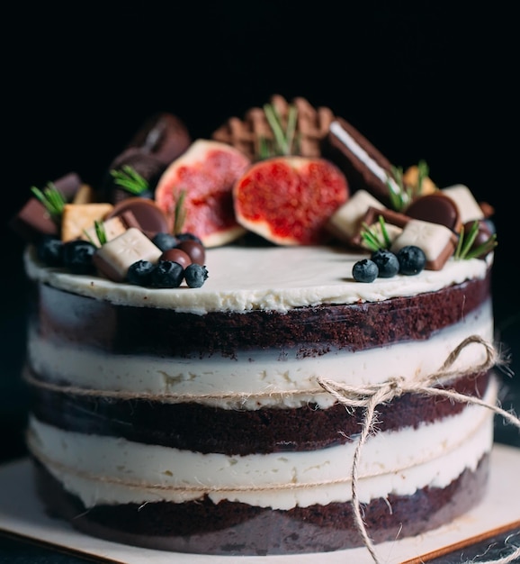 Photo fruit cake decorated with figs, cookies and blueberries.