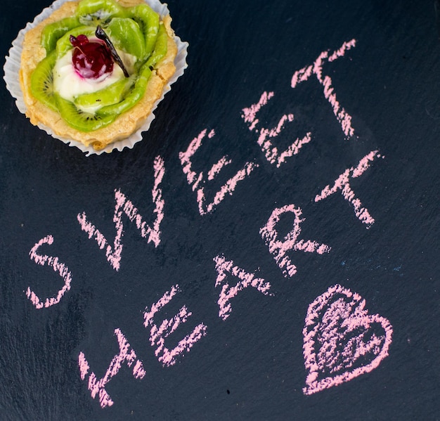 Photo fruit cake on a stone board with an inscription chalksweet heart