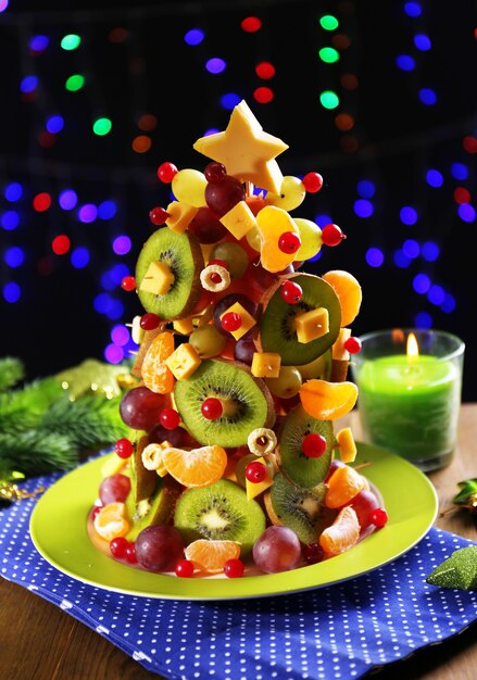 Fruit Christmas tree on table on dark background