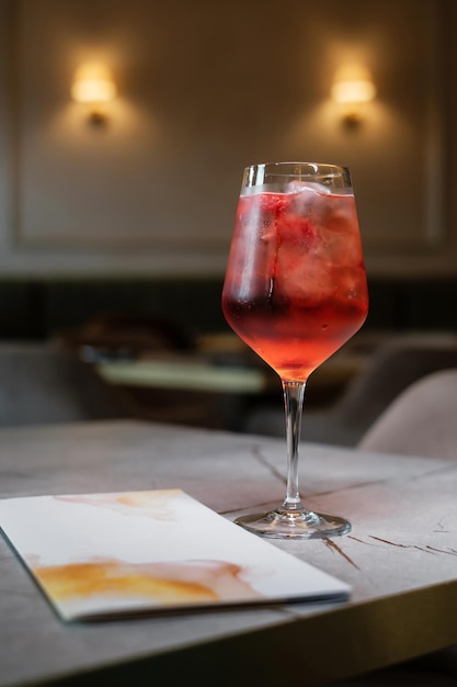 Fruit cocktail with drinks menu on stone table