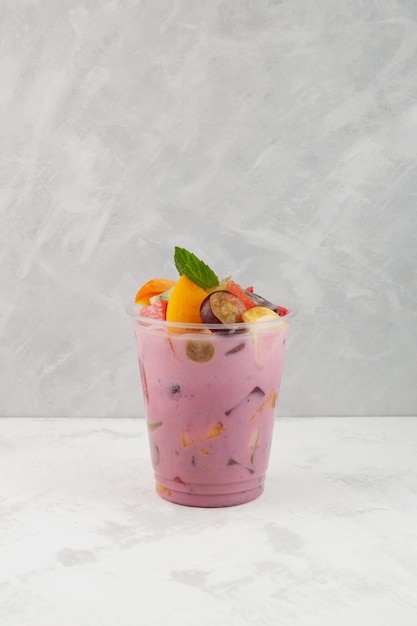 Fruit cocktail with yogurt in disposable plastic take away cup Es Campur or Sop Buah