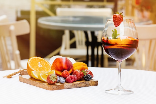 fruit cocktails on white wooden table with berries and mint leaves