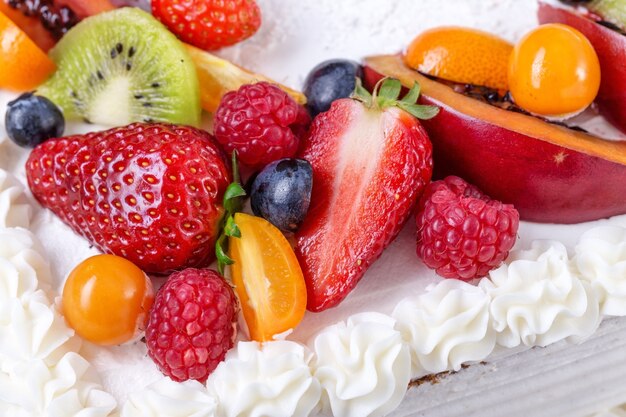 Foto torta alla crema di frutta con fragole su una ragazza di compleanno.