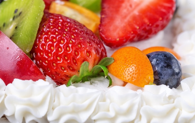 Fruit cream cake with strawberries on a birthday girl.