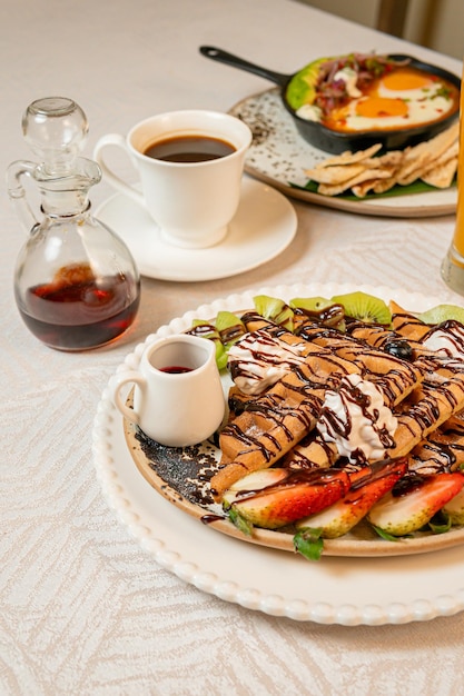 Fruit crepes with chocolate and maple syrup for breakfast