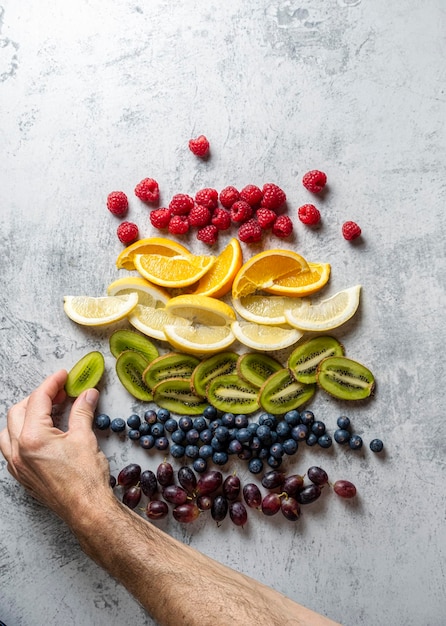 Fruit cut and arranged in the order of the colors of the rainbow One hand places the fruit in order