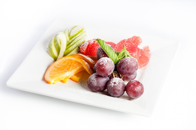 Fruit dessert on a square plate on a white background