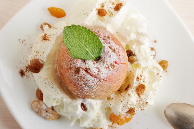 Fruit dessert  with baked Apple with icing sugar on plate