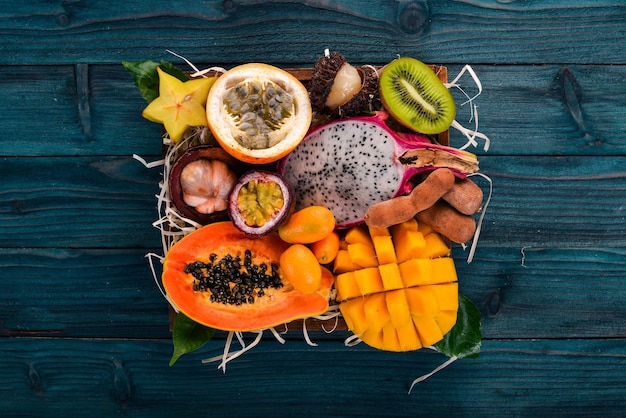 Fruit dragon papaya maracuya kiwi mango and granadilla in a wooden box Fresh Tropical Fruits On a wooden background Top view Copy space