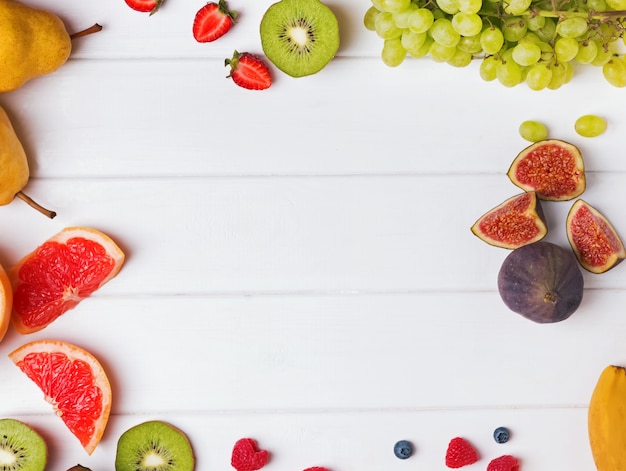 Fruit en bessen op witte tafel, bovenaanzicht