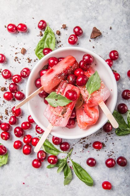 Fruit en bessenijslollys met kersen in een kom