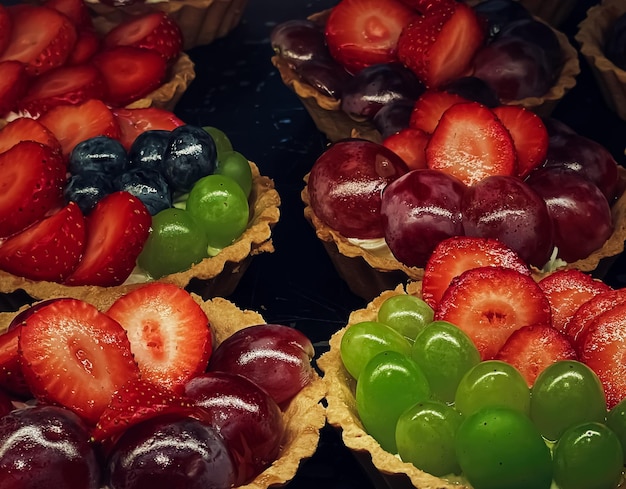 Fruit en bessentaartjes en taarten als fruitdessert, zoet eten en heerlijk gebak in de bakkerij