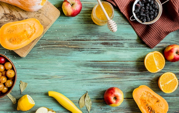 Fruit en honing in een pot op het oude turquoise ruwe houten tafelblad uitzicht